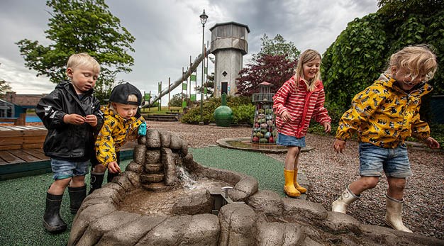 Fyra barn som leker med vattenleken i Vattenkraftens lekplats. 