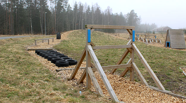 Hinderbana med bildäck och ett hinder i trä