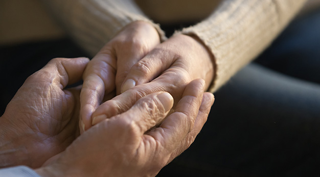Två personer som håller varandras händer som stöd