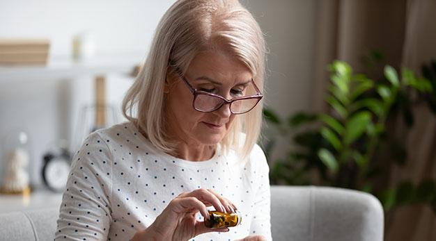 Äldre dam tar medicin