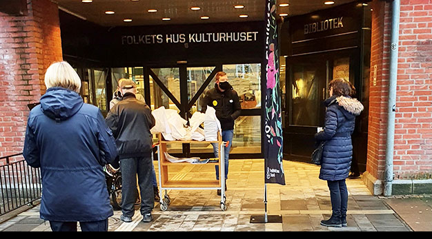 Folk köar utanför biblioteket i väntan på sin tur .