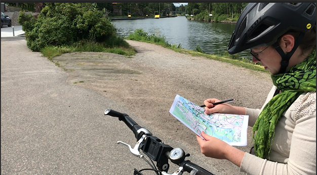 Cyklist med karta i handen
