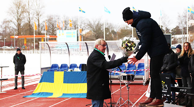 Paul Åkerlund lämnar över blombukett till Nils van der Poel vid ceremonin på Edsborg.