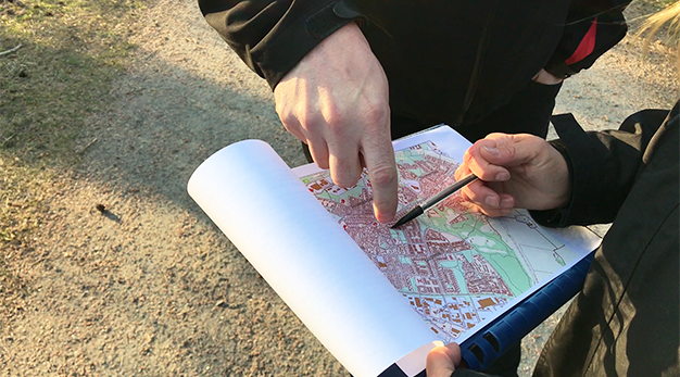 Två personer pekar på en karta över ett område i Trollhättan