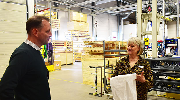 Helena Törneröd tar tacksamt emot plastförkläden från Leif Gustavsson, vd för Argynnis Group. 