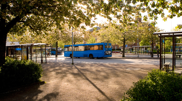 Buss på torget, grönska i bakgrunden