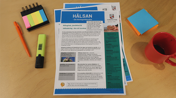 En hög av Hälsanblad liggandes på ett bort omgivet av kontorsmaterial.