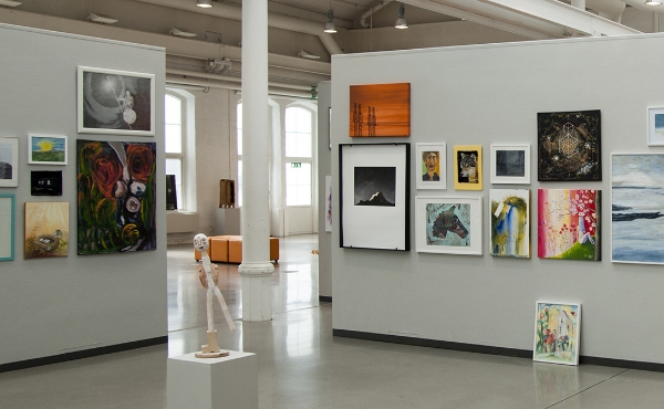 Galleri eller museum med flera tavlor på väggarna. Foto.