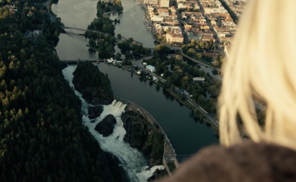 Kvinna blickar ut över Trollhättans fall från hög höjd. Foto.