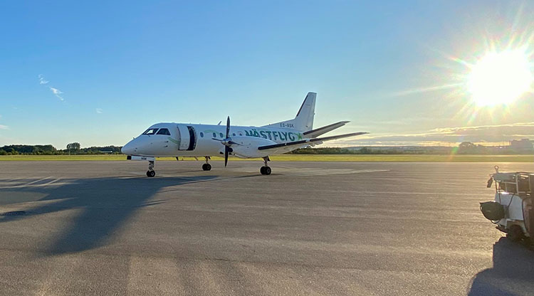 Västflygs flygplan står på plattan i solsken.
