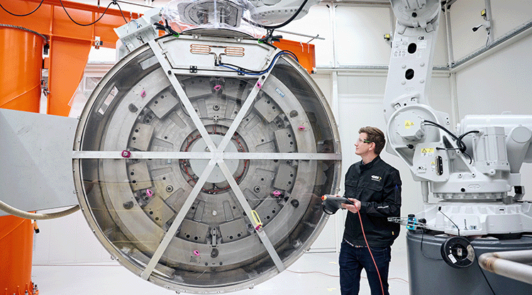 En bild på en av GKN Aerospace motorer och en person som står bredvid och jobbar med den