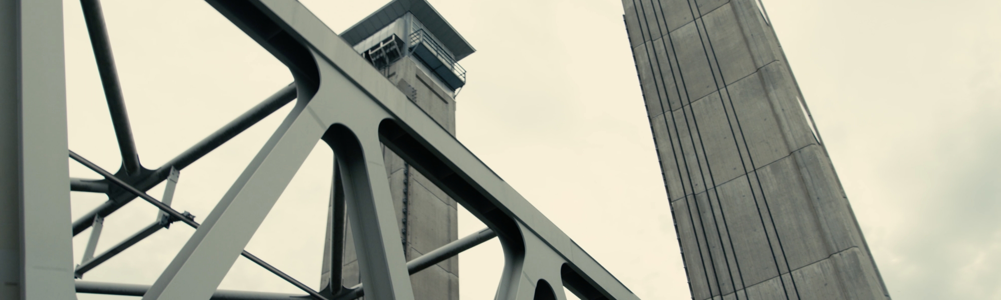 Järnbalk i förgrunden ser ut att vara en del av en tågbro. Foto.