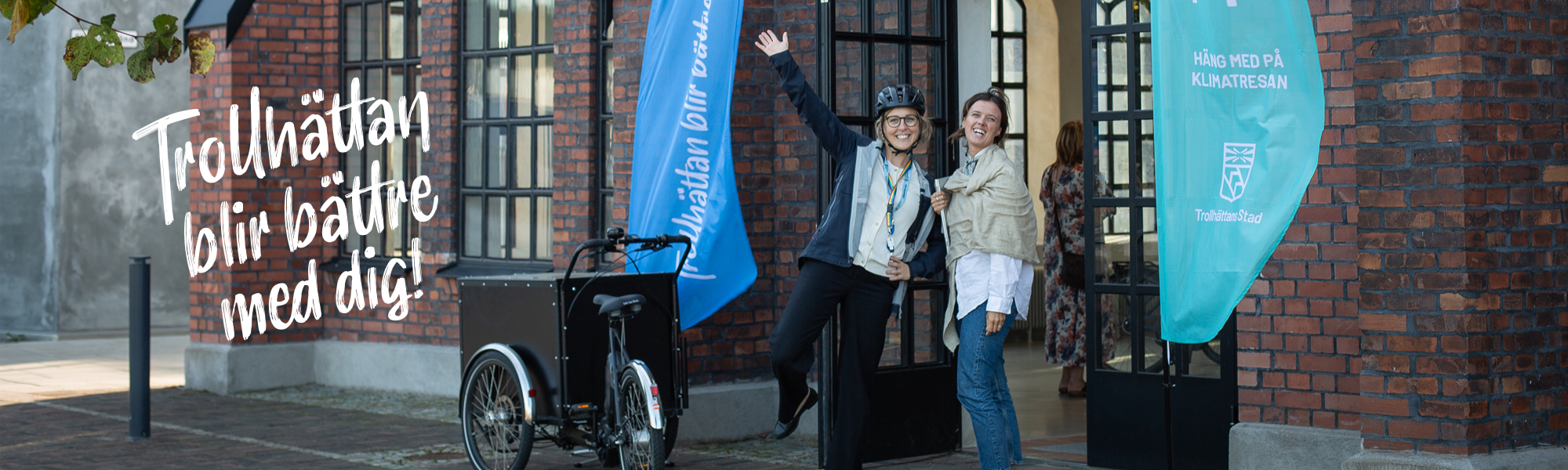 Två personer utomhus med en lådcykel.