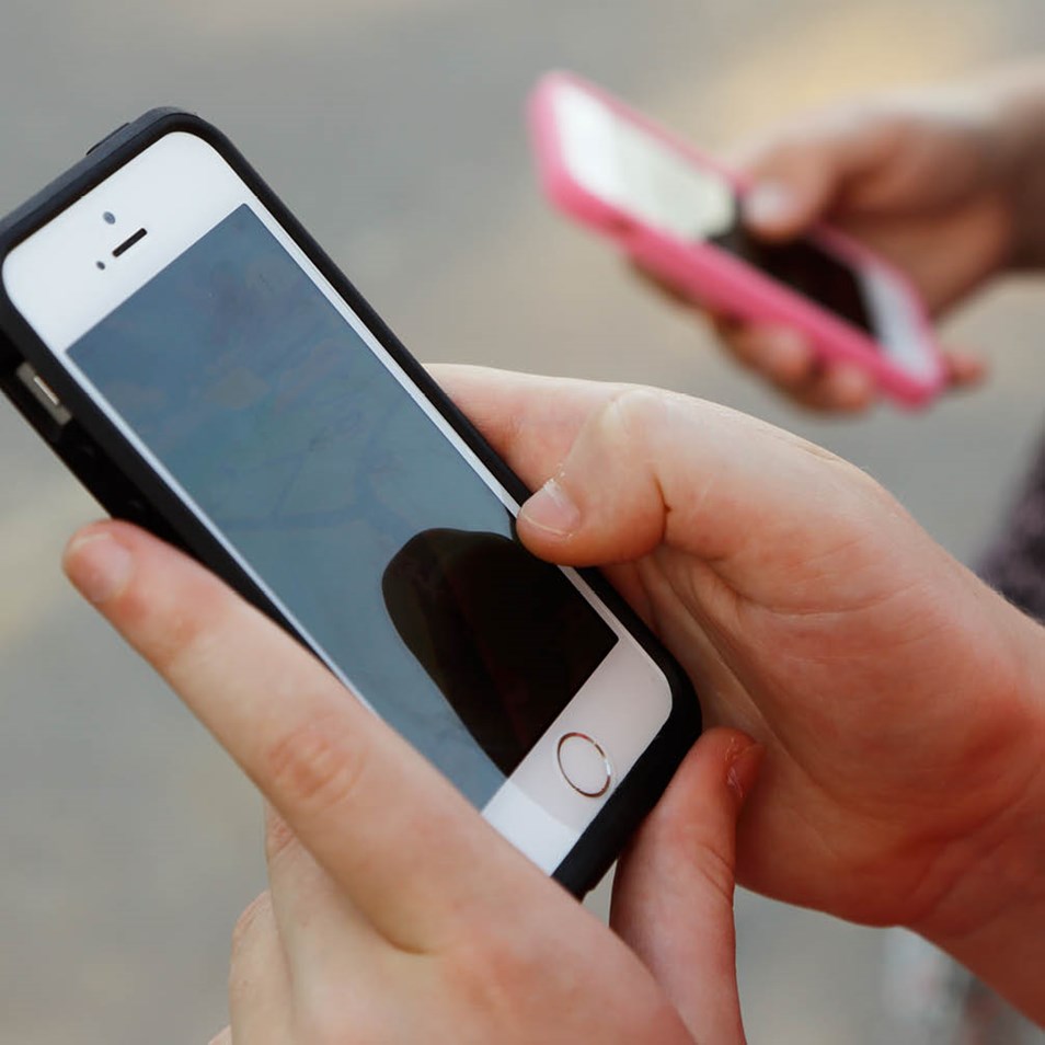 Två personer som håller varsin smarttelefon. 