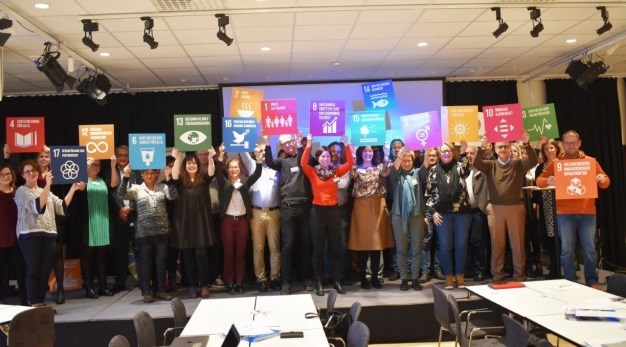 Politiker och personal i Trollhättans Stad håller upp skyltar för de 17 globala målen.