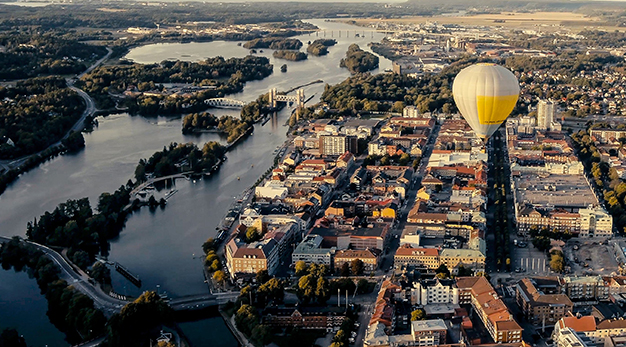 Bilden är en drönarbild över spikön och de centrala delarna av staden. Mitt i bild syns en stor gul luftballong. 