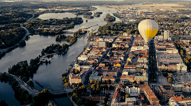 Bilden är en drönarbild över spikön och de centrala delarna av staden. Mitt i bild syns en stor gul luftballong.