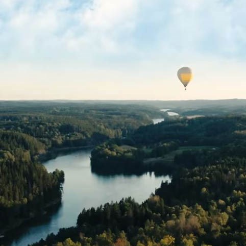 Vybild över Göta Älv och skog en gul luftballong i luften