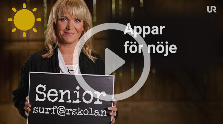 Kattis Ahlström håller upp en griffeltavla med texten Senior-surf@rskolan. På sidan av bilden står det: Appar för nöje.