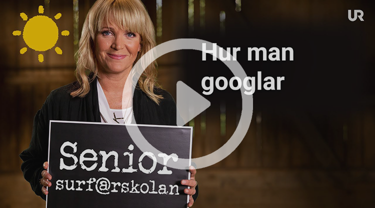 Kattis Ahlström håller upp en griffeltavla med texten Senior-surf@rskolan. På sidan av bilden står det: Hur man googlar.