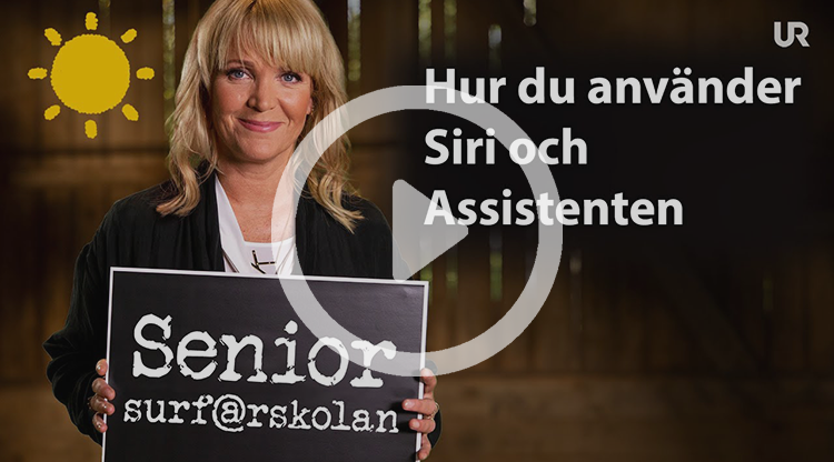 Kattis Ahlström håller upp en griffeltavla med texten Senior-surf@rskolan. På sidan av bilden står det: Hur du använder Siri och Assistenten.