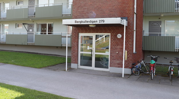 Entrédörrar till byggnadshus. Ovanför entrén är det en skylt där det står Bergkullevägen 279.