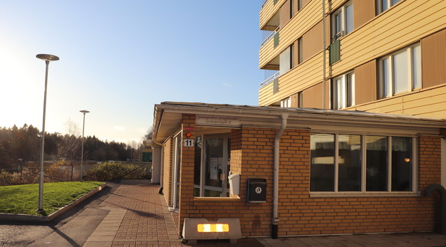 Entré utomhus gul tegelbyggnad, blå himmel.