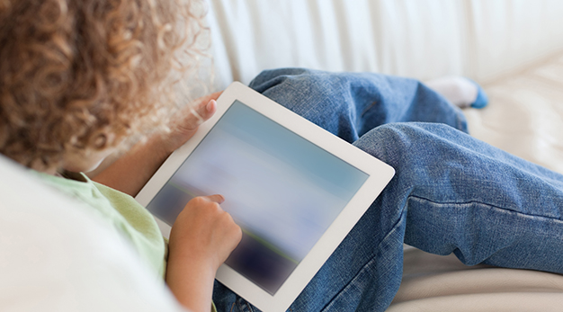 Baen med Ipad sittandes i soffa