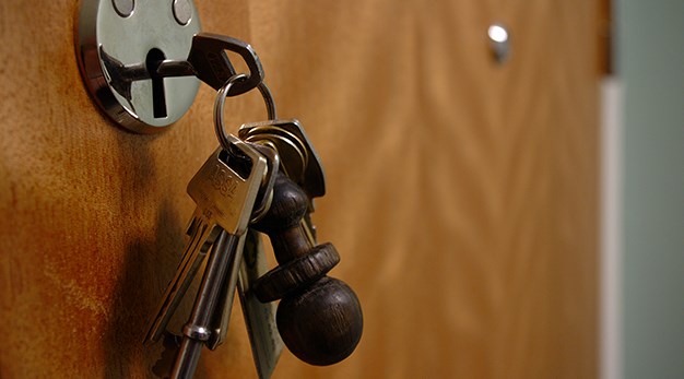 Nyckelknippa som sitetr i ett lås i en dörr