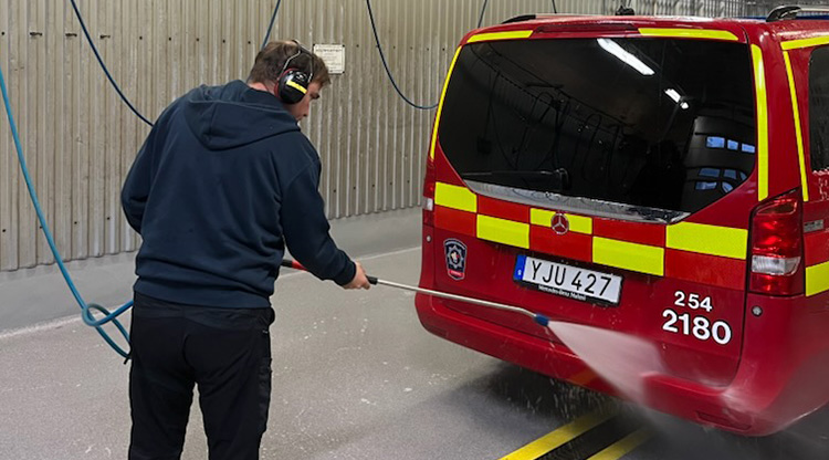 Kille fotad bakifrån när han tvättar ett utryckningsfordon