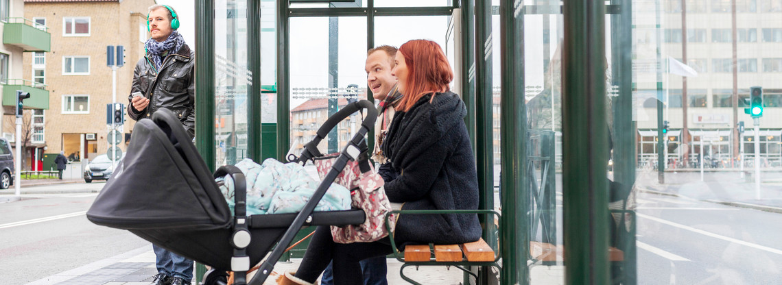 Par med vagn i busshållplats