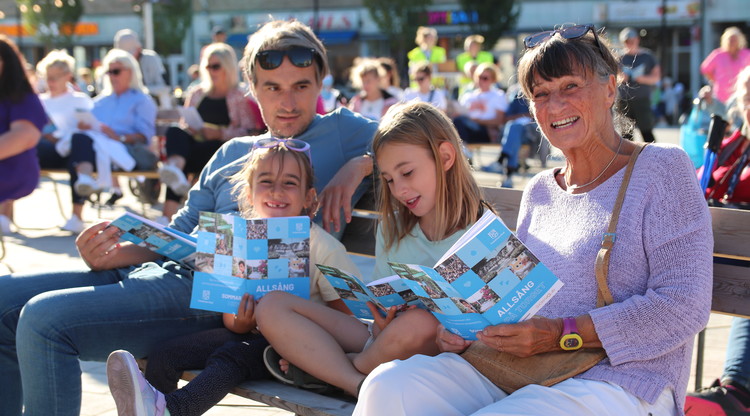 Familj på en bänk på torget under eventet "Allsång på torget"