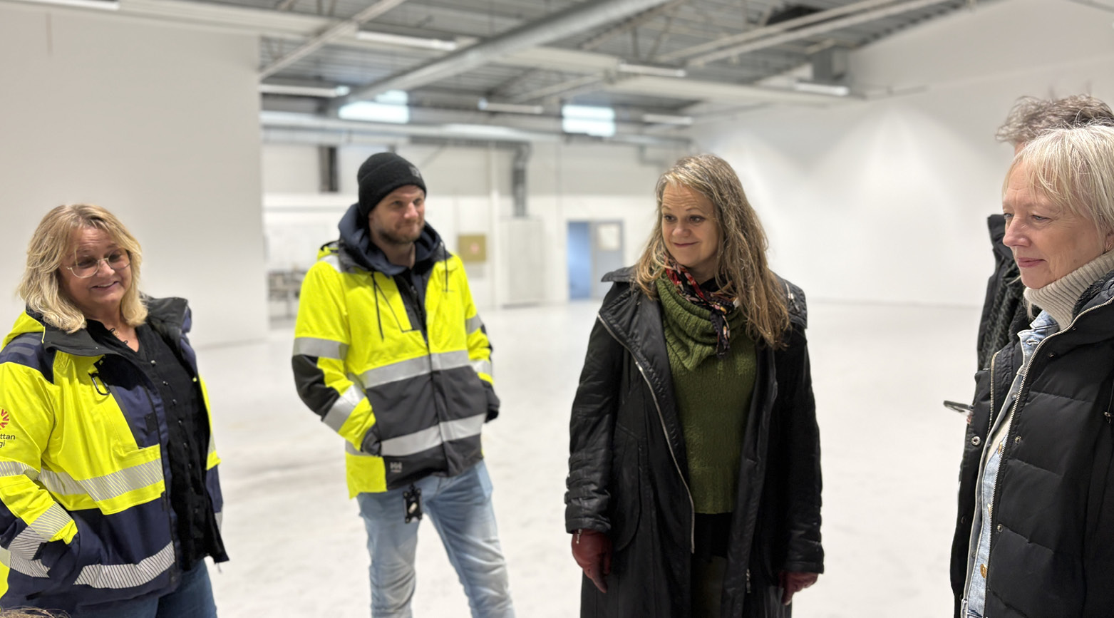Tre kvinnor och en man i en vit verksamhetslokal. 