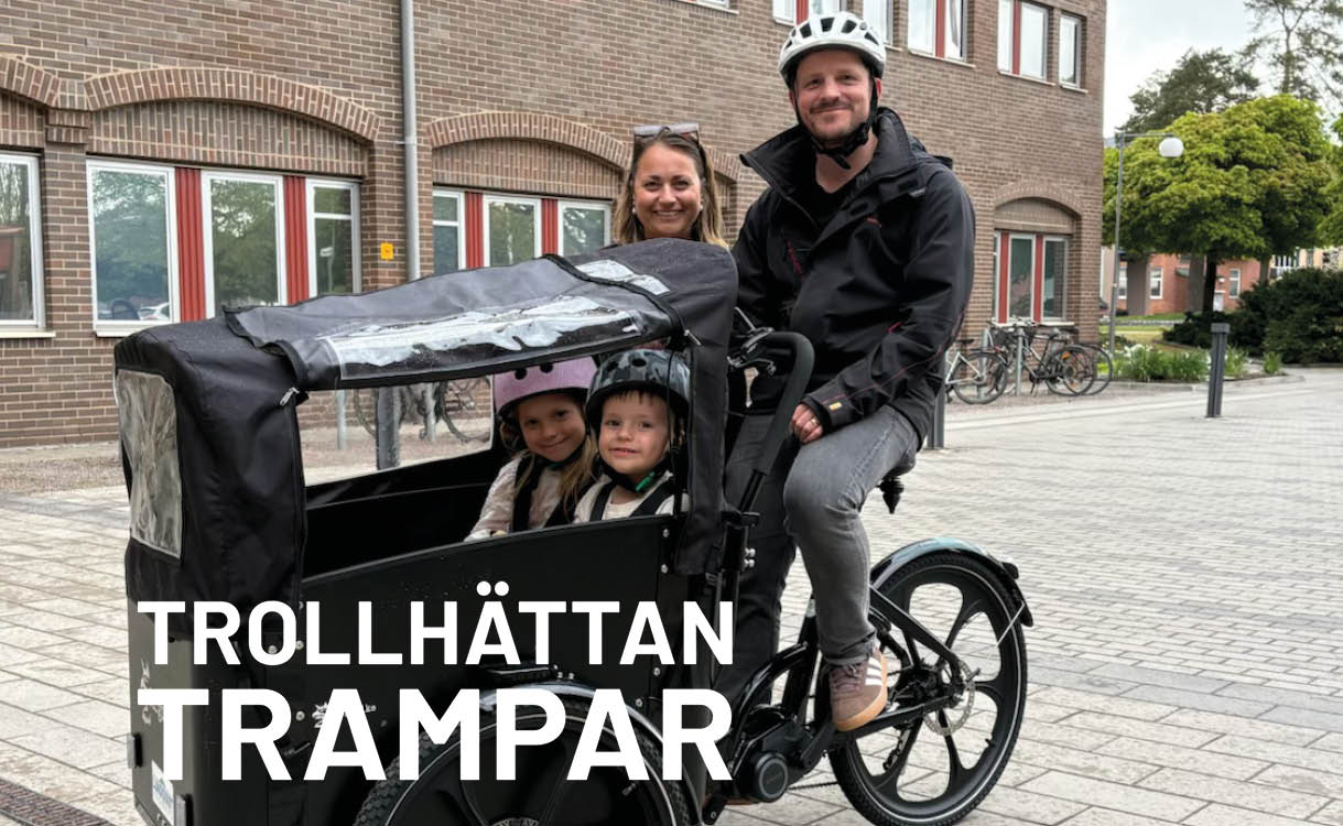 Man och kvinna bakom ellådcykel med barn i lådan.