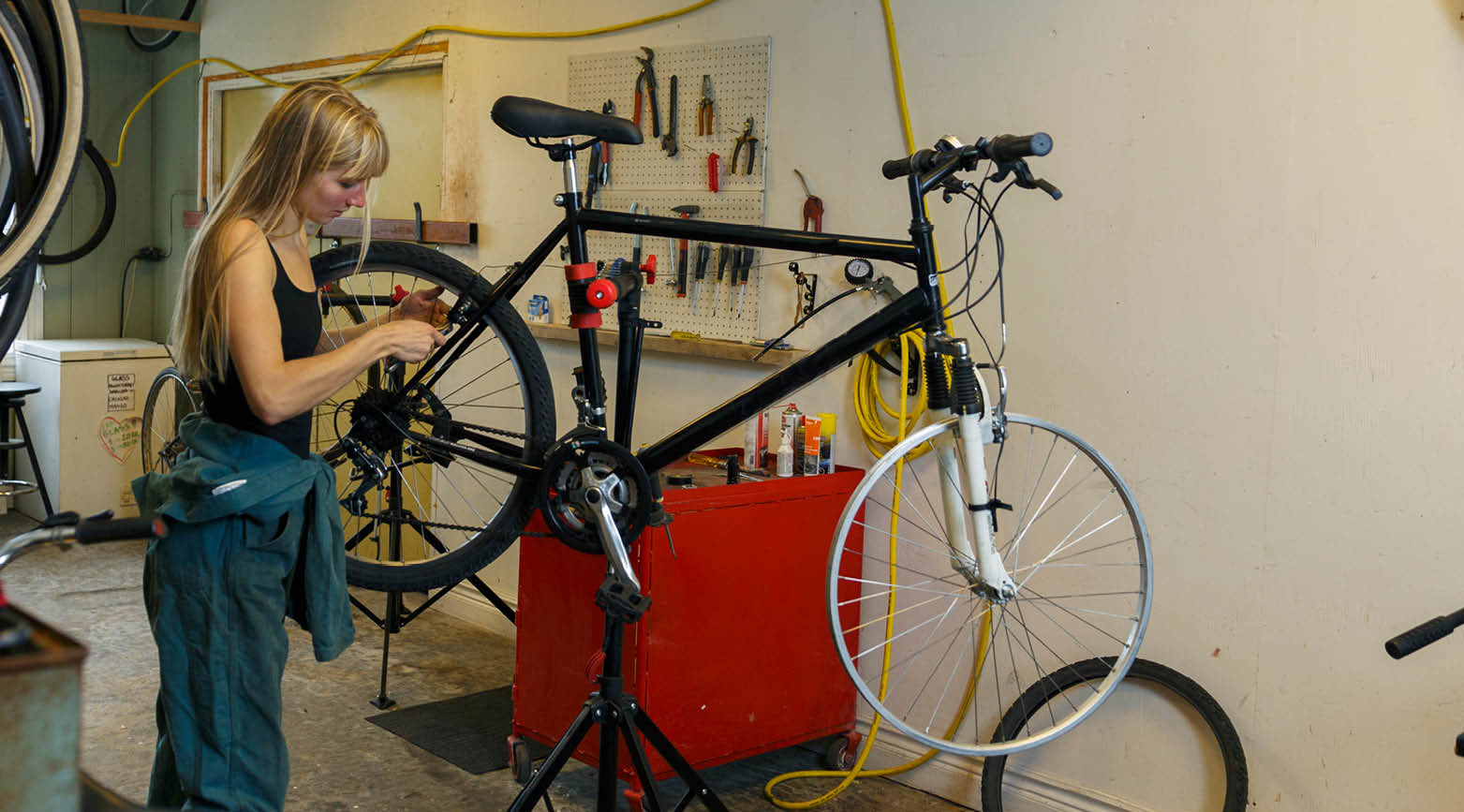 Kvinna som reparerar cykel i verkstad