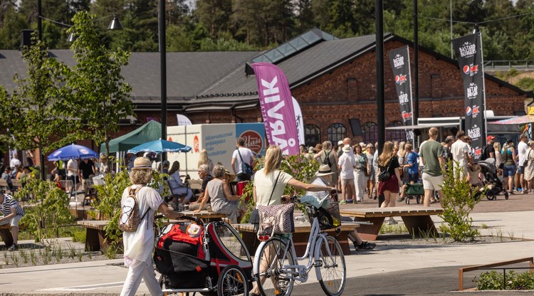 Människor som går och cyklar framför Filfabriken på Vårvik