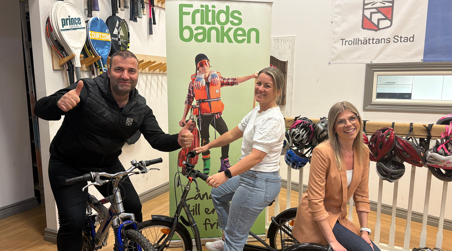 Aslan Agirman, Camilla Karlsson och Louise Olsson på cyklar i Fritidsbankens lokaler.
