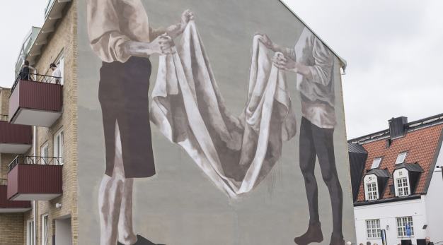 Muralmålning som visar två kvinnogestalter som viker tvätt.