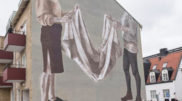 Muralmålning som visar två kvinnogestalter som viker tvätt.