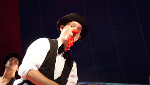 Clown med en röd trasa i munnen