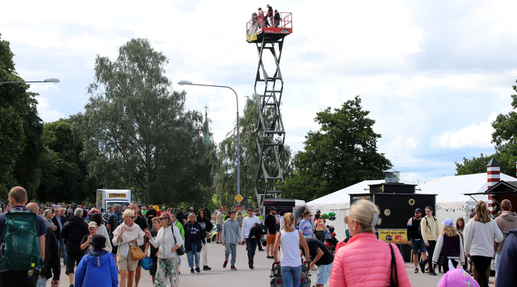 Personer går runt och tittar vid aktivitetstält. I bakgrunden syns personer uppe på en skylift.