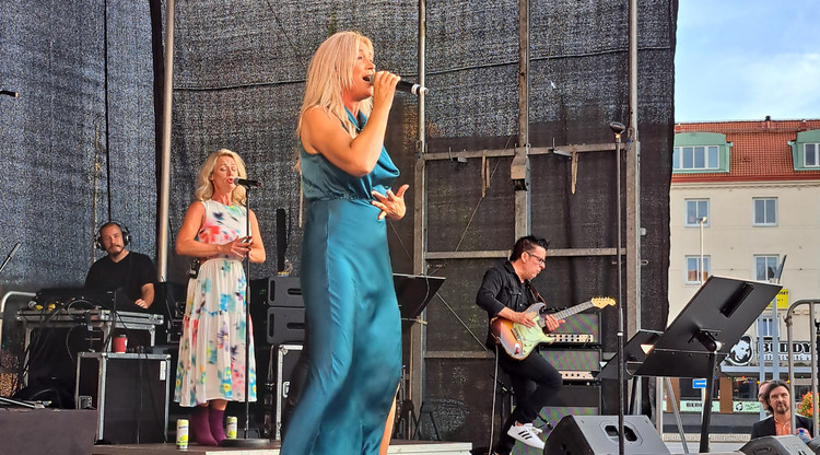 Artisten Jessica Andersson sjunger på scen med ett band.