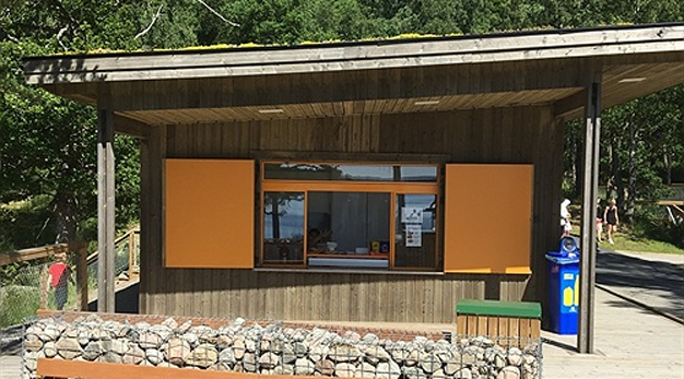 Kiosk i trä och sten men lucka för servering