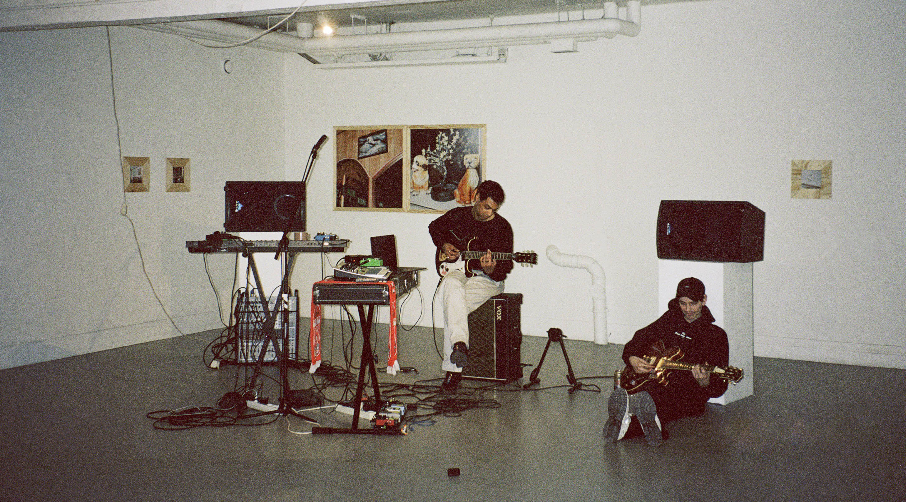 Bandet ABUS LANG sitter med instrument framför tavlor.