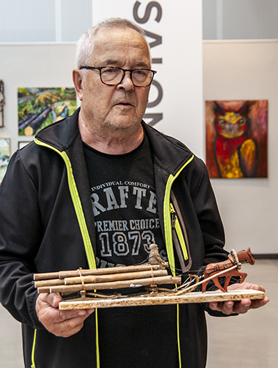 En man håller upp sitt bidrag till Öppen salong 2020, en skulptur som tolkar temat skog.