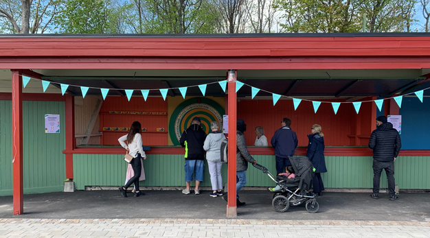 Lotteribod med spelhjul där några personer står 