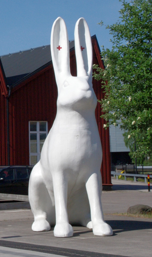 Staty på en vit albinohare med röda kors i öronen