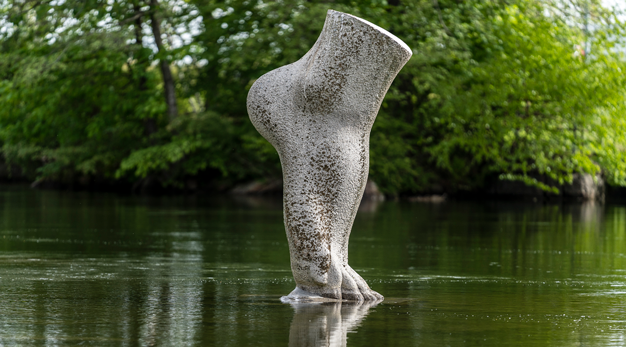 Stor stenskulptur av en fot placerad i vatten