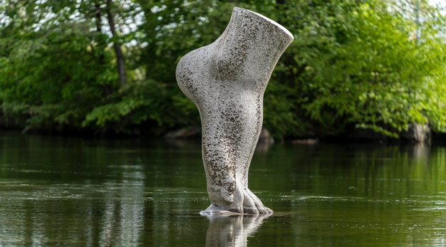 Stor stenskulptur av en fot placerad i vatten
