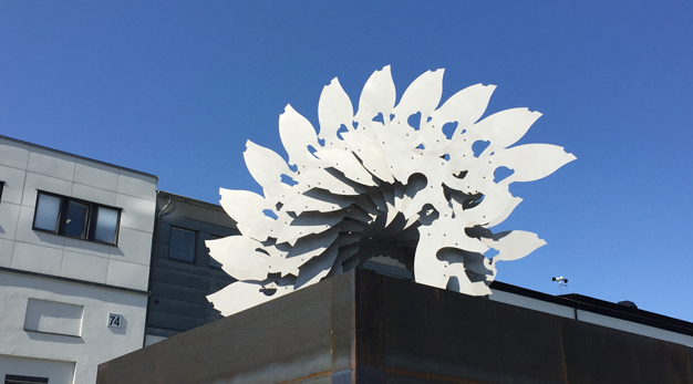 Metallskulptur står ovanpå en hög låda i corténstål.
